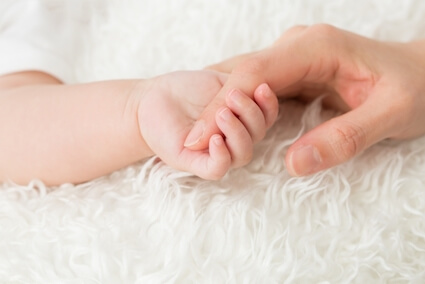 親の人差し指を握る赤ちゃん