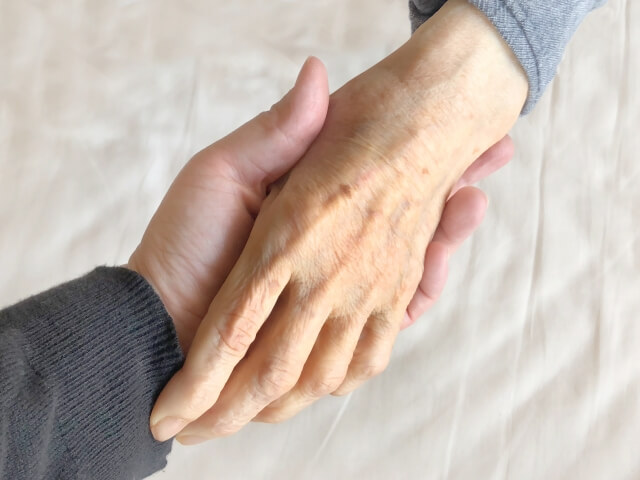 おばあちゃんの手を握る娘