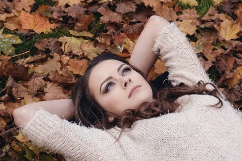 公園で枯葉の上で寝そべっている女性