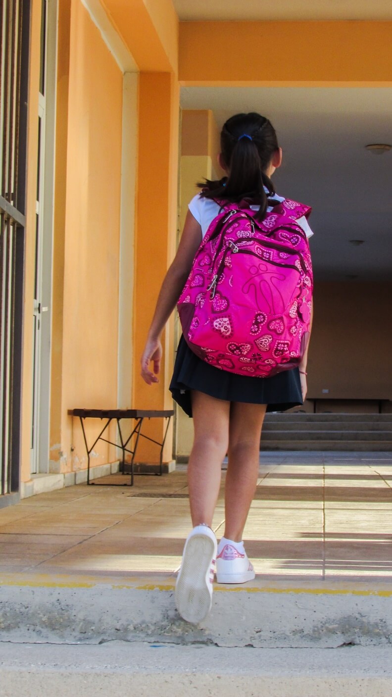 ピンクのリュックサックを背負って学校に向かう少女