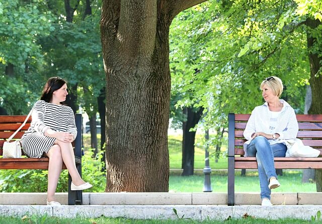 公園のベンチでアイコンタクトを取っている二人の女性